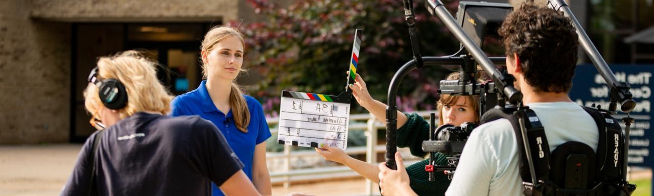 Behind the seats of a video shoot as a student speaks directly to camera